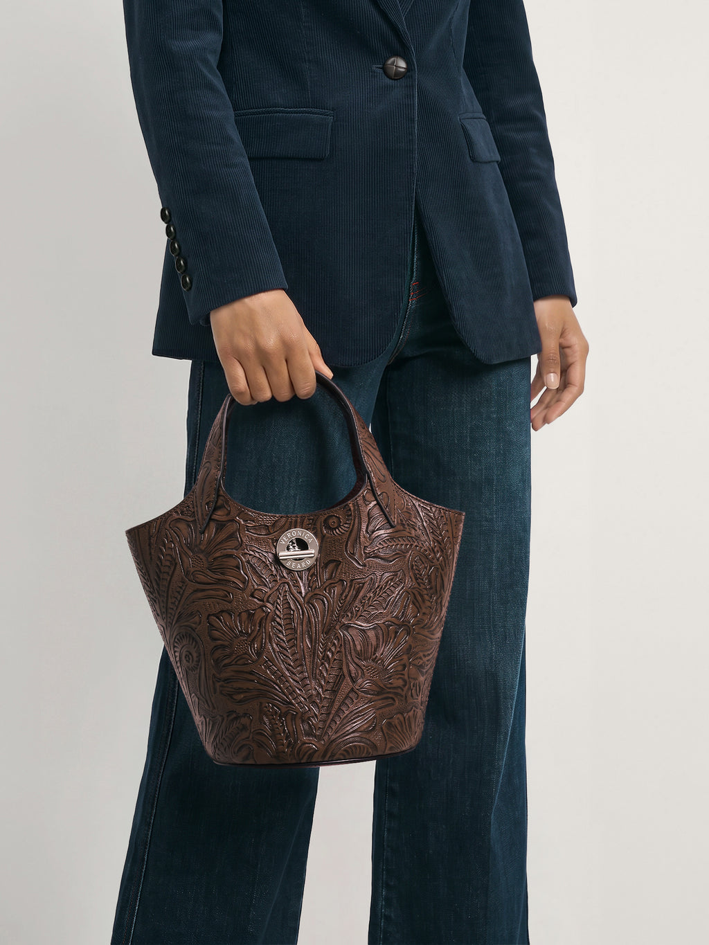 Veronica Beard Brown embossed leather handbag with circular logo detail.