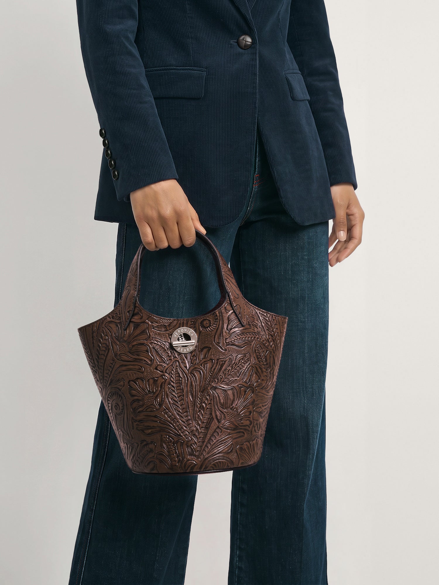 Veronica Beard Brown embossed leather handbag with circular logo detail.