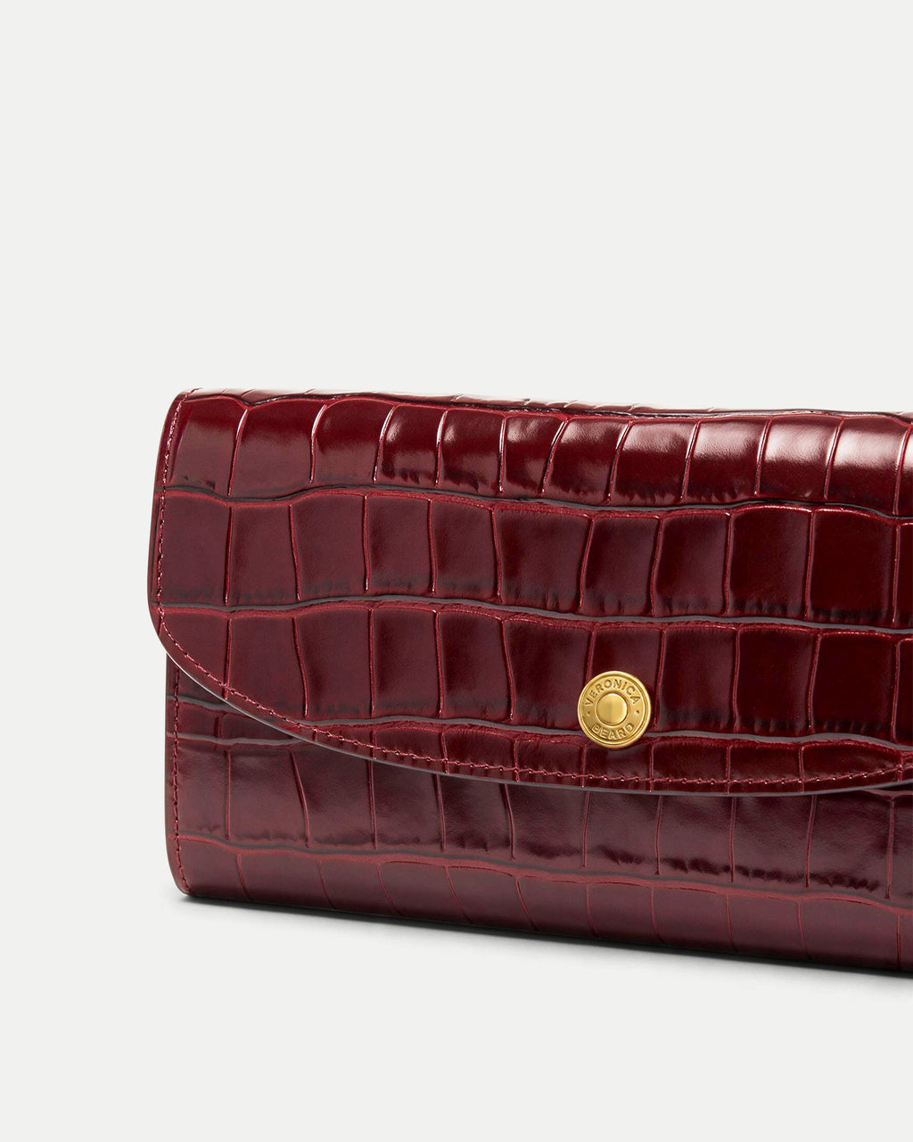 Veronica Beard Burgundy embossed leather wallet with gold snap button.