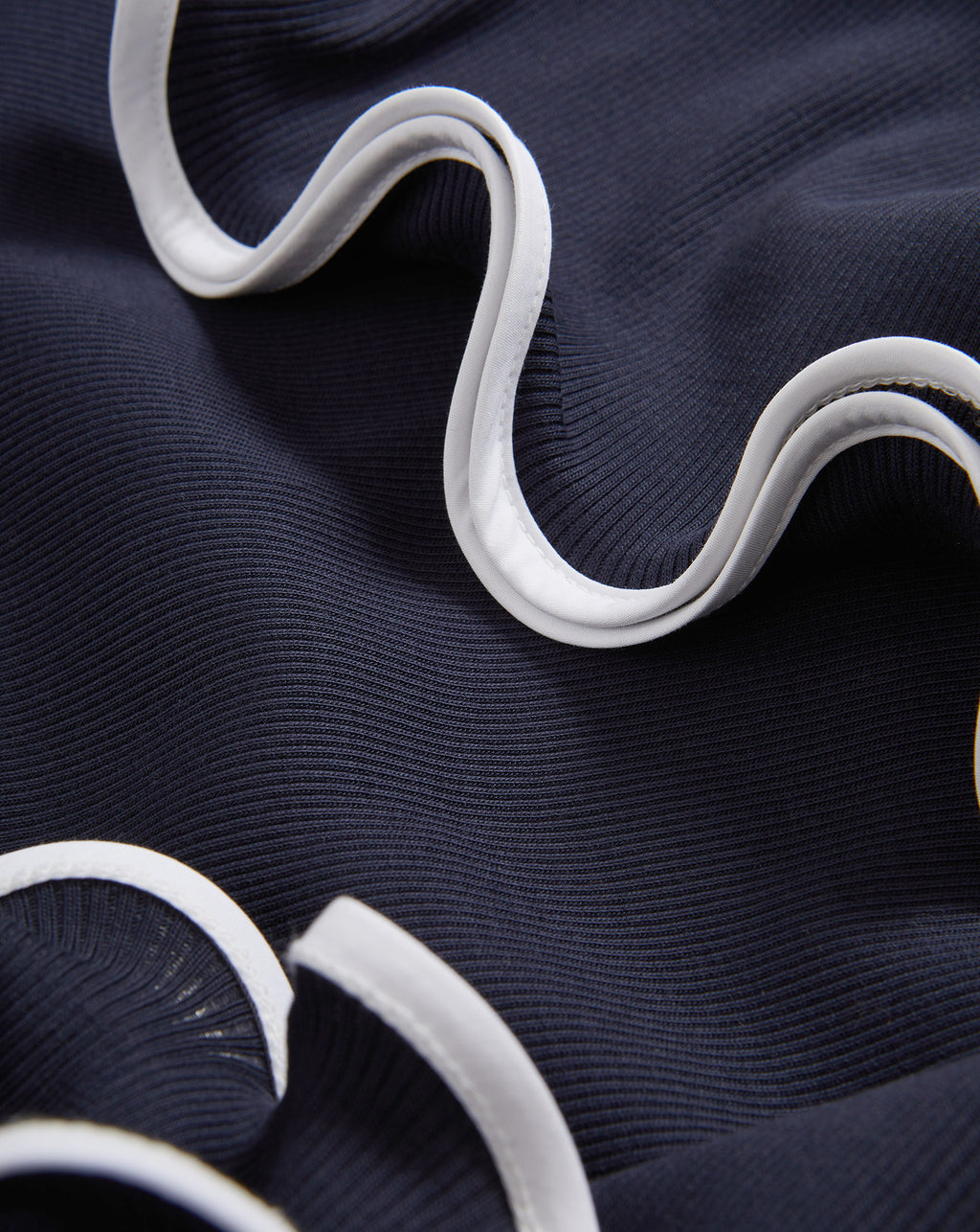 Veronica Beard Navy ribbed knit fabric with white ruffled trim.