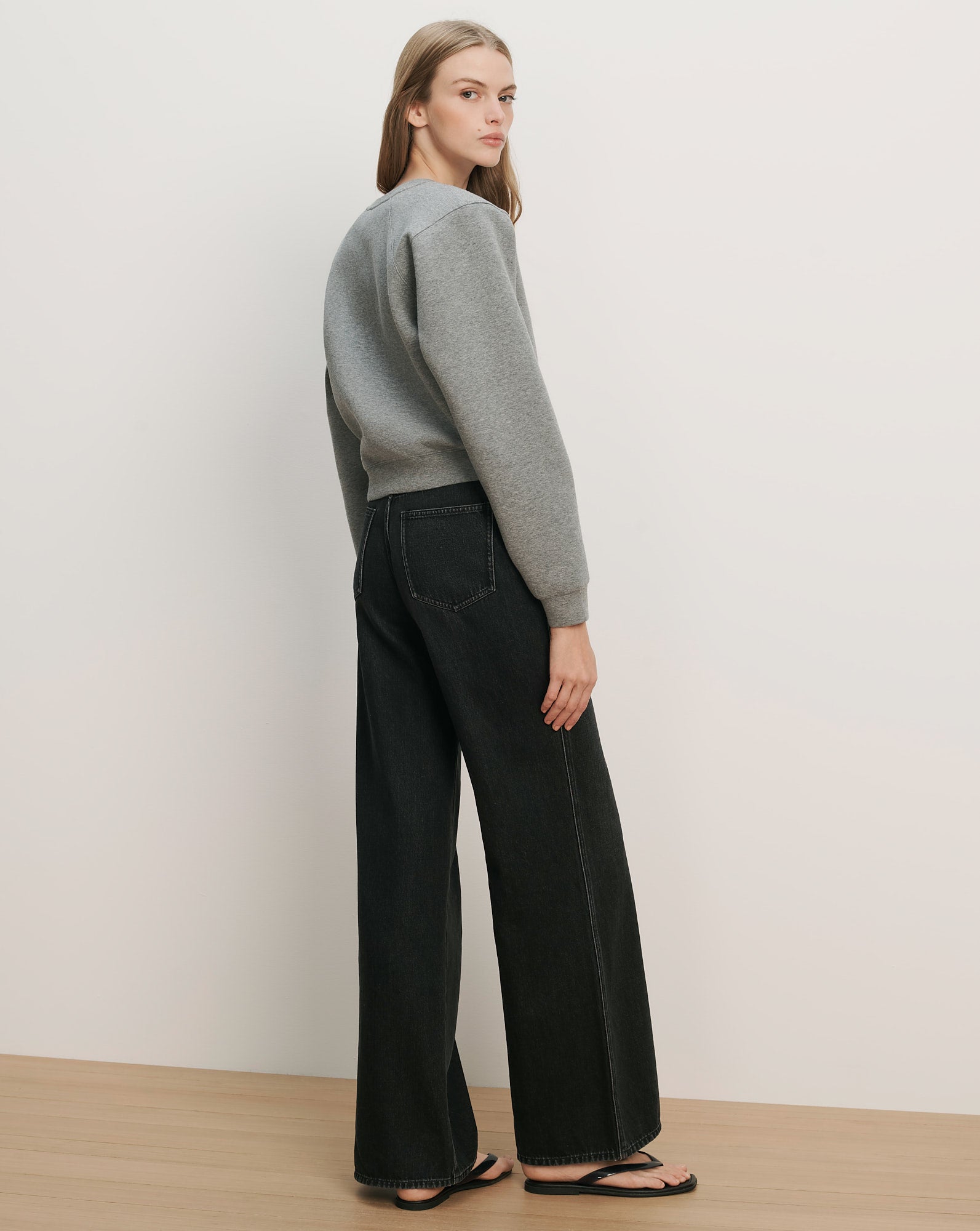 Veronica Beard Gray crewneck sweatshirt and black wide-leg jeans with white stitching.