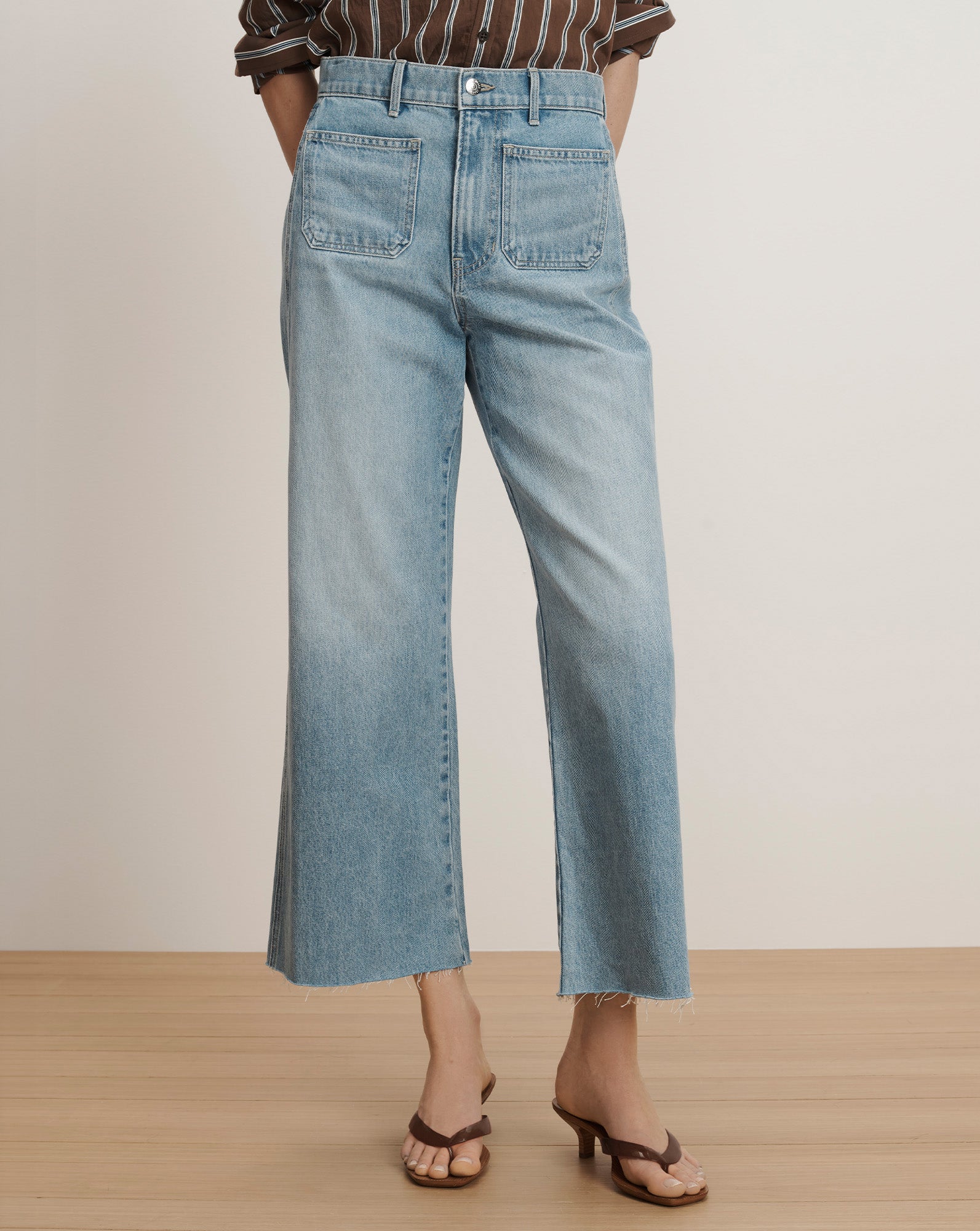 Veronica Beard Light wash wide-leg jeans with front patch pockets and a raw hem.