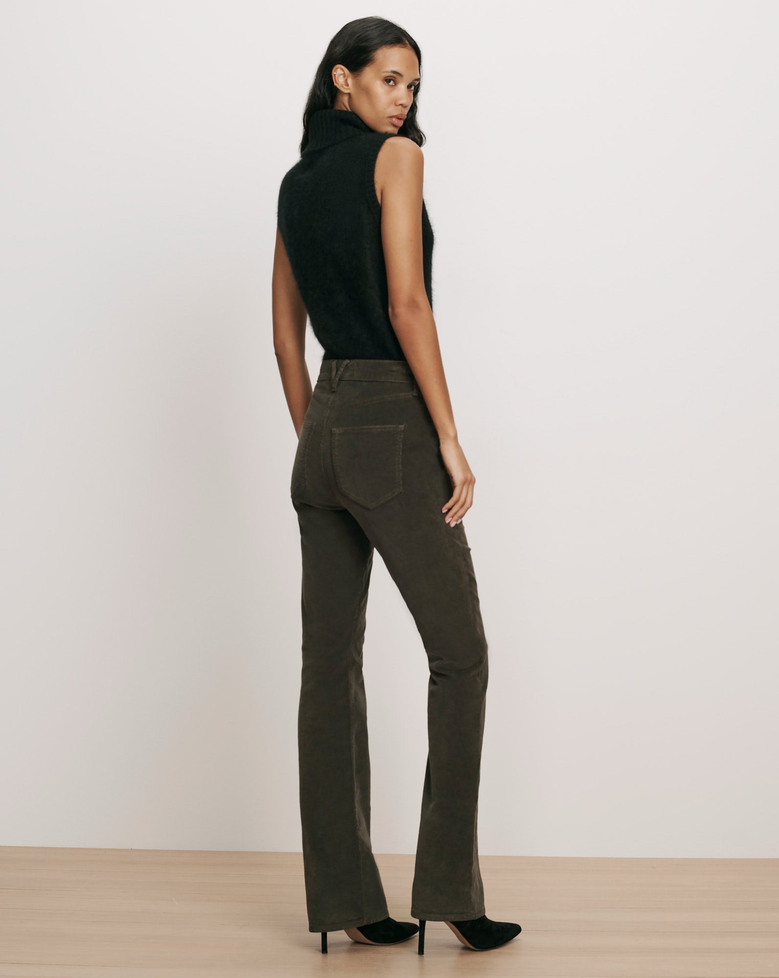 Veronica Beard Black sleeveless turtleneck top and dark green trousers.