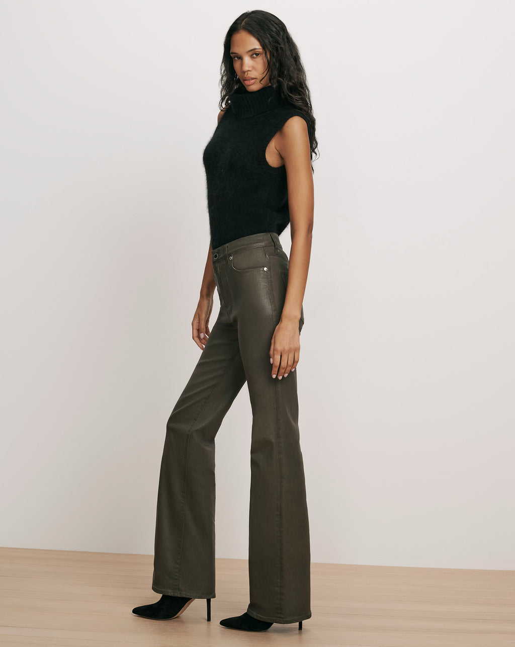 Veronica Beard Black sleeveless turtleneck and dark green flared pants.