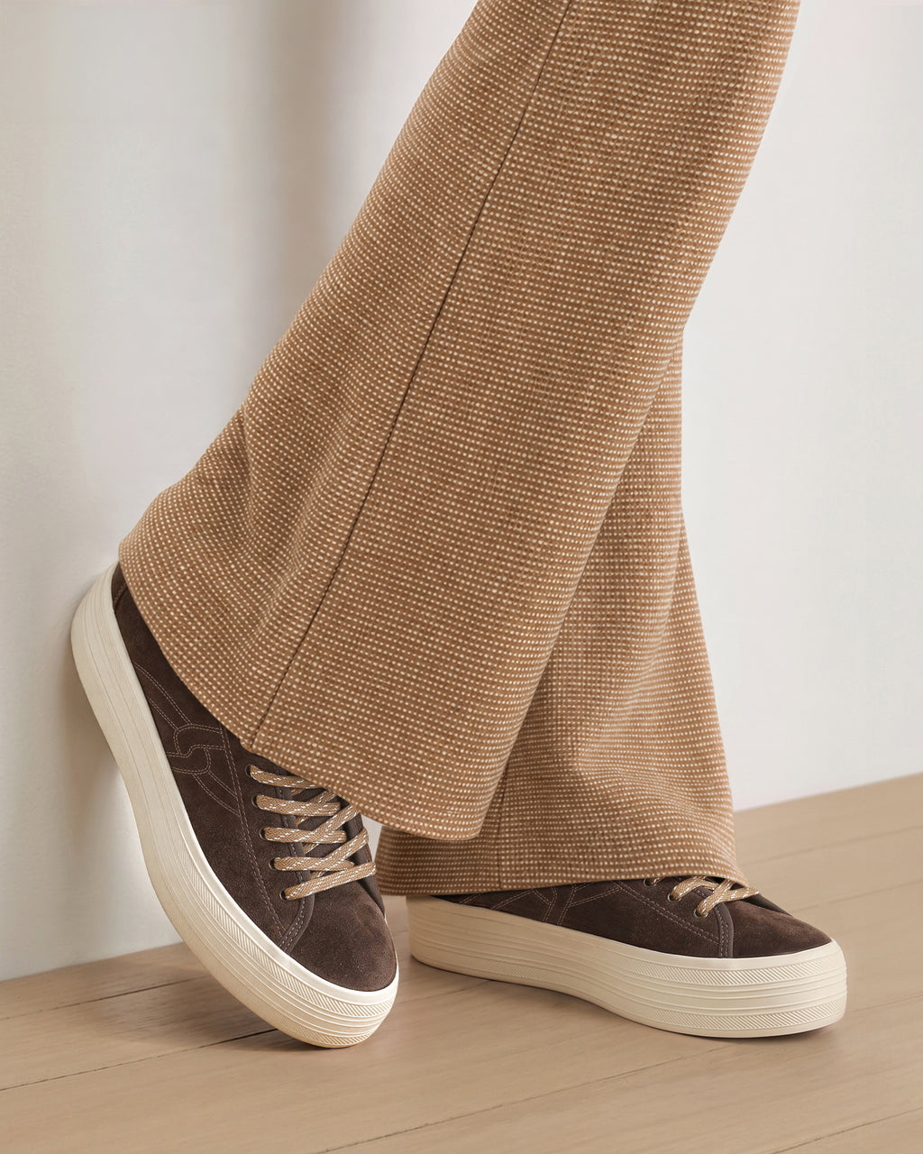 Veronica Beard Brown patterned flare trousers and platform sneakers.