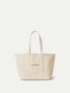Veronica Beard Beige canvas tote bag with red script embroidery.