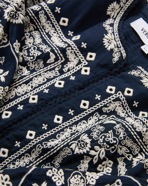 Veronica Beard Black embroidered jacket, white top, and white shorts.